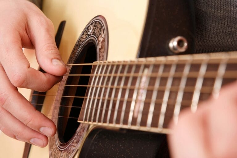 Eine Nahaufnahme einer Person, die während eines Gottesdienstes in Fürth eine Akustikgitarre spielt.