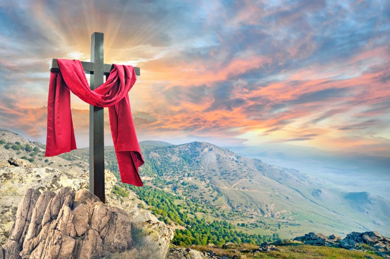 Ein Kreuz auf einem Berg mit einem roten Schal, der Jesus darstellt.